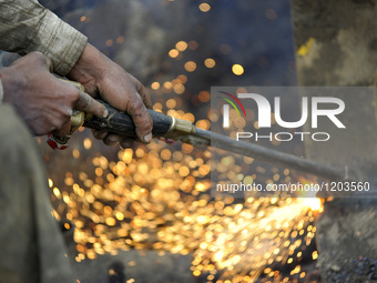 SUDHIR KUMAR PATEL, 28 yrs old, migrated from India Cutting heavy duty roller's Metal with Oxygen Acetylene Gas as Spark splash around the g...