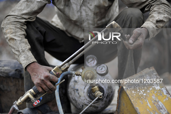 SUDHIR KUMAR PATEL, 28 yrs old, migrated from India checks Oxygen gas after changing cylinder to cut heavy duty roller with Oxygen Acetylene...