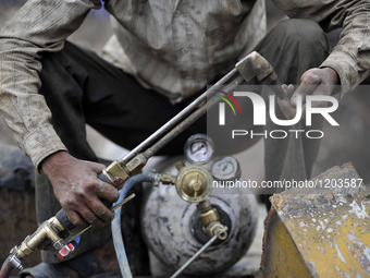 SUDHIR KUMAR PATEL, 28 yrs old, migrated from India checks Oxygen gas after changing cylinder to cut heavy duty roller with Oxygen Acetylene...