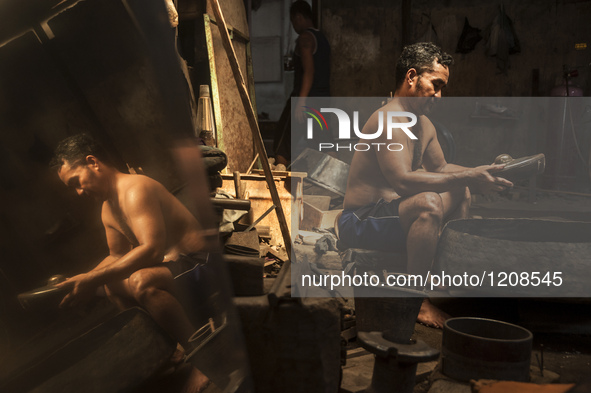 A worker checking gamelan in Gamelan Daliyo Legiyono, Pelem Lor Batu Retno Village, Banguntapan, Yogyakarta, Indonesia, on May 13, 2016. Gam...