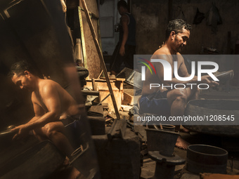 A worker checking gamelan in Gamelan Daliyo Legiyono, Pelem Lor Batu Retno Village, Banguntapan, Yogyakarta, Indonesia, on May 13, 2016. Gam...