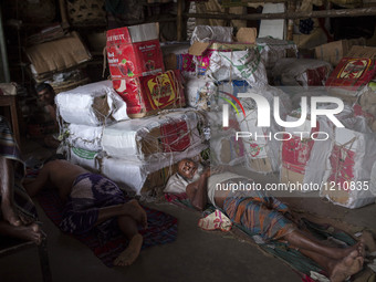 DHAKA, BANGLADESH - MAY 12: Labourers of Karwan Bazar break for a mid-day siesta to beat the hot summer noon in their workplace at Karwan Ba...