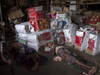 DHAKA, BANGLADESH - MAY 12: Labourers of Karwan Bazar break for a mid-day siesta to beat the hot summer noon in their workplace at Karwan Ba...