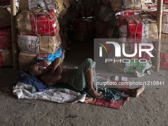 DHAKA, BANGLADESH - MAY 12: Labourers of Karwan Bazar break for a mid-day siesta to beat the hot summer noon in their workplace at Karwan Ba...