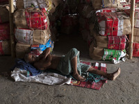 DHAKA, BANGLADESH - MAY 12: Labourers of Karwan Bazar break for a mid-day siesta to beat the hot summer noon in their workplace at Karwan Ba...