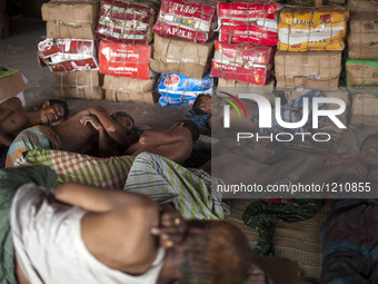 DHAKA, BANGLADESH - MAY 12: Labourers of Karwan Bazar break for a mid-day siesta to beat the hot summer noon in their workplace at Karwan Ba...