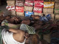 DHAKA, BANGLADESH - MAY 12: Labourers of Karwan Bazar break for a mid-day siesta to beat the hot summer noon in their workplace at Karwan Ba...