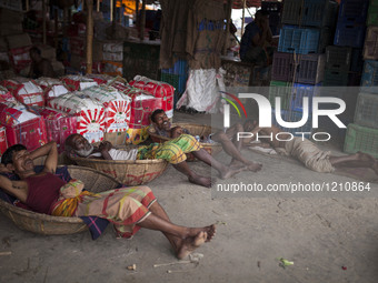 DHAKA, BANGLADESH - MAY 12: Labourers of Karwan Bazar break for a mid-day siesta to beat the hot summer noon in their workplace at Karwan Ba...