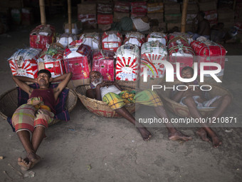 DHAKA, BANGLADESH - MAY 12: Labourers of Karwan Bazar break for a mid-day siesta to beat the hot summer noon in their workplace at Karwan Ba...