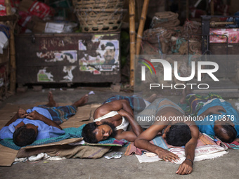 DHAKA, BANGLADESH - MAY 12: Labourers of Karwan Bazar break for a mid-day siesta to beat the hot summer noon in their workplace at Karwan Ba...