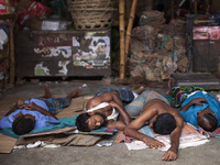 DHAKA, BANGLADESH - MAY 12: Labourers of Karwan Bazar break for a mid-day siesta to beat the hot summer noon in their workplace at Karwan Ba...