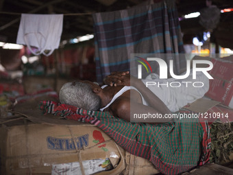 DHAKA, BANGLADESH - MAY 12: Labourers of Karwan Bazar break for a mid-day siesta to beat the hot summer noon in their workplace at Karwan Ba...