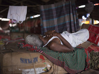 DHAKA, BANGLADESH - MAY 12: Labourers of Karwan Bazar break for a mid-day siesta to beat the hot summer noon in their workplace at Karwan Ba...