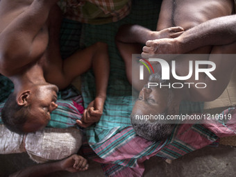 DHAKA, BANGLADESH - MAY 12: Labourers of Karwan Bazar break for a mid-day siesta to beat the hot summer noon in their workplace at Karwan Ba...