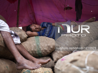 DHAKA, BANGLADESH - MAY 12: Labourers of Karwan Bazar break for a mid-day siesta to beat the hot summer noon in their workplace at Karwan Ba...