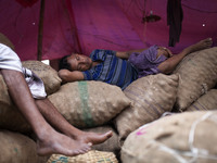 DHAKA, BANGLADESH - MAY 12: Labourers of Karwan Bazar break for a mid-day siesta to beat the hot summer noon in their workplace at Karwan Ba...