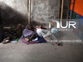 DHAKA, BANGLADESH - MAY 12: Labourers of Karwan Bazar break for a mid-day siesta to beat the hot summer noon in their workplace at Karwan Ba...