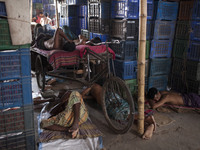 DHAKA, BANGLADESH - MAY 12: Labourers of Karwan Bazar break for a mid-day siesta to beat the hot summer noon in their workplace at Karwan Ba...