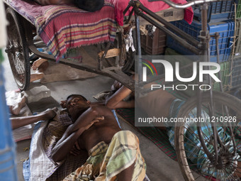 DHAKA, BANGLADESH - MAY 12: Labourers of Karwan Bazar break for a mid-day siesta to beat the hot summer noon in their workplace at Karwan Ba...