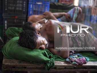 DHAKA, BANGLADESH - MAY 12: Labourers of Karwan Bazar break for a mid-day siesta to beat the hot summer noon in their workplace at Karwan Ba...