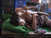 DHAKA, BANGLADESH - MAY 12: Labourers of Karwan Bazar break for a mid-day siesta to beat the hot summer noon in their workplace at Karwan Ba...