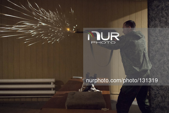 A militiaman from the Russian Orthodox Army practices shooting firearms at the unit's headquarters in the occupied SBU building in Donetsk,...