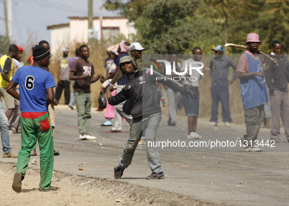 A protester hurls stones towards police during a protest in the impoverished suburb of Epworth on the outskirts of Harare, Zimbabwe, July 4,...