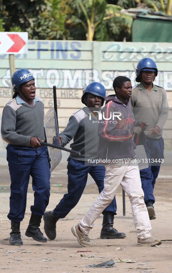 Police arrest a protester during a protest in the impoverished suburb of Epworth on the outskirts of Harare, Zimbabwe, July 4, 2016. Zimbabw...