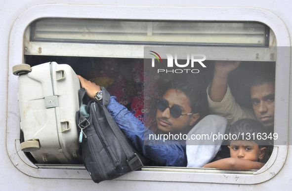 Passengers squeeze in a train leaving for their hometowns for the upcoming Eid al-Fitr festival in Dhaka, Bangladesh, July 5, 2016.