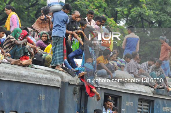 Passengers travel on top of a train leaving for their hometowns for the upcoming Eid al-Fitr festival in Dhaka, Bangladesh, July 5, 2016.