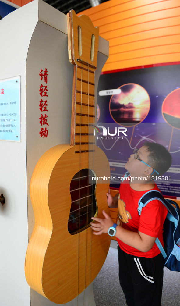 A child tries an exhibit at Zhengzhou Science Museum during summer vacation in Zhengzhou, capital of central China's Henan Province, July 6,...