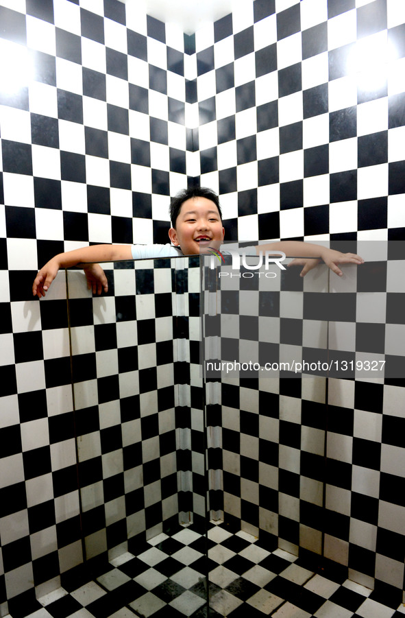 A child tries an exhibit at Zhengzhou Science Museum during summer vacation in Zhengzhou, capital of central China's Henan Province, July 6,...