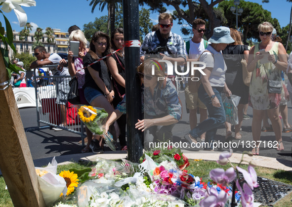 People offer flowers to the victims near the site of the terrorist attack in Nice, France, July 15, 2016. The death toll rises to 84 from an...