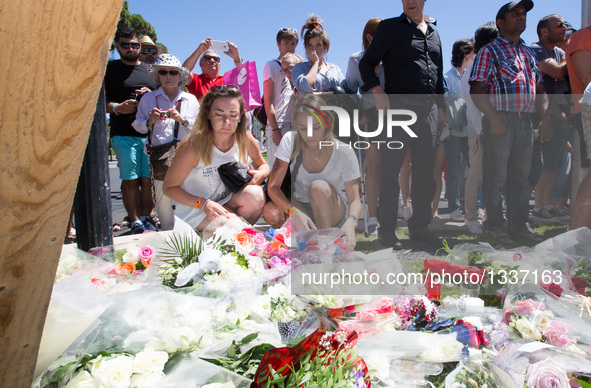 People offer flowers to the victims near the site of the terrorist attack in Nice, France, July 15, 2016. The death toll rises to 84 from an...