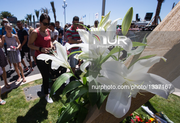 People offer flowers to the victims near the site of the terrorist attack in Nice, France, July 15, 2016. The death toll rises to 84 from an...