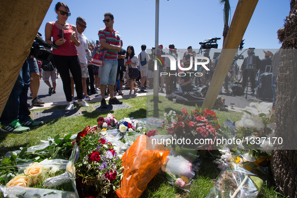 People offer flowers to the victims near the site of the terrorist attack in Nice, France, July 15, 2016. The death toll rises to 84 from an...