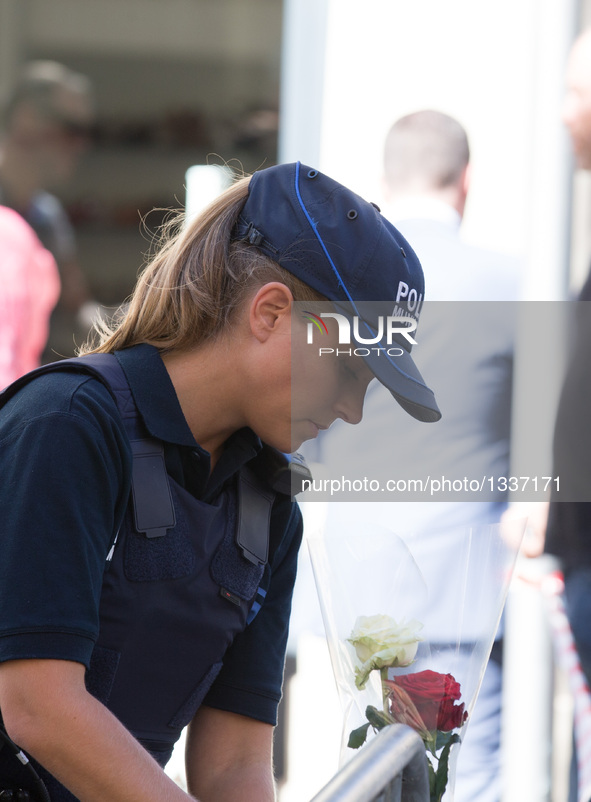 A policewoman arranges flowers offered to the victims near the site of the terrorist attack in Nice, France, July 15, 2016. The death toll r...