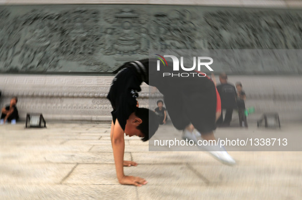 A student of a Peking Opera troupe practises basic skills at Kaiyuan Temple Square in Xingtai, north China's Hebei Province, July 17, 2016....