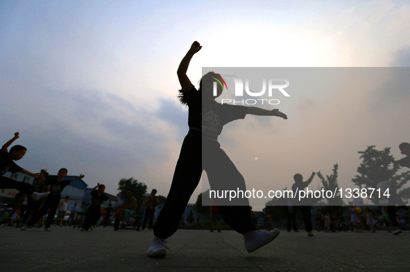 Students of a Peking Opera troupe practise basic skills at Kaiyuan Temple Square in Xingtai, north China's Hebei Province, July 17, 2016. Ma...