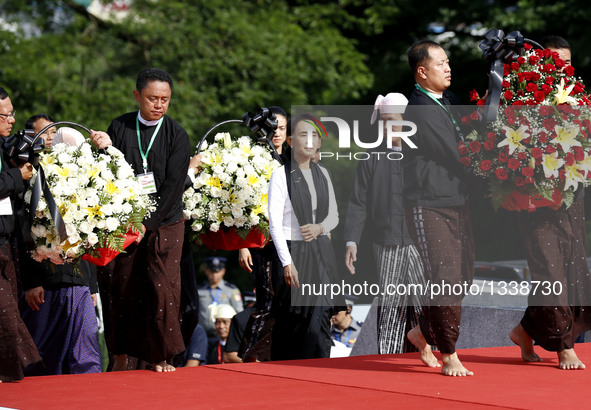 Myanmar's State Counselor Aung San Suu Kyi (C), daughter of General Aung San, pays tribute during a ceremony to mark the 69th Martyrs' Day i...