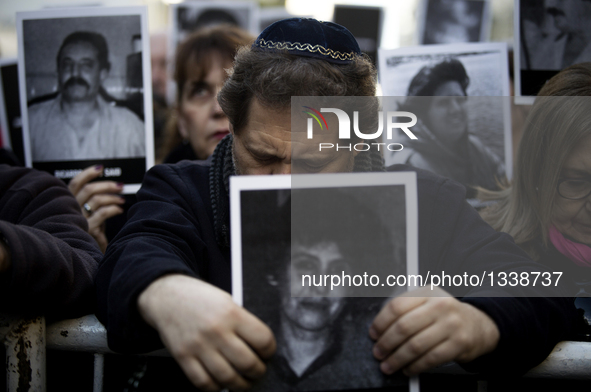 A man holds a victim's picture during a commemoration of the 22nd anniversary of a terrorist attack on a Jewish center in 1994 in Buenos Air...