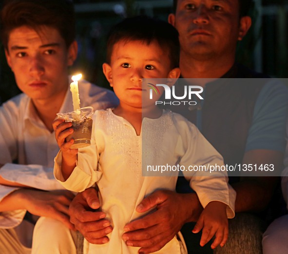 People attend a candlelight vigil to commemorate victims of Kabul twin bomb attack in Herat province, Afghanistan, July 24, 2016. In total 8...