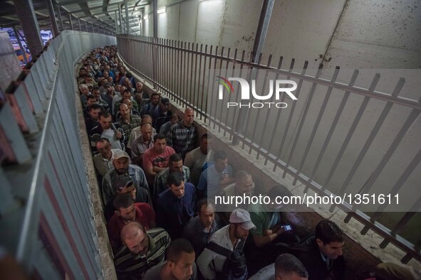 Palestinian labourers, working in Israel, make their way to their workplaces, through the main Israeli terminal in the West Bank city of Bet...