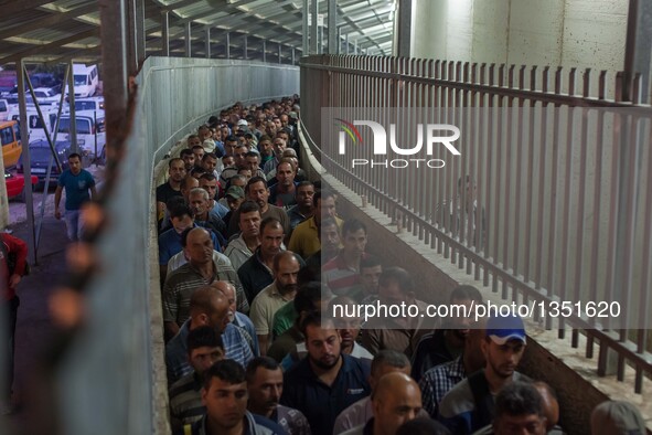 Palestinian labourers, working in Israel, make their way to their workplaces, through the main Israeli terminal in the West Bank city of Bet...