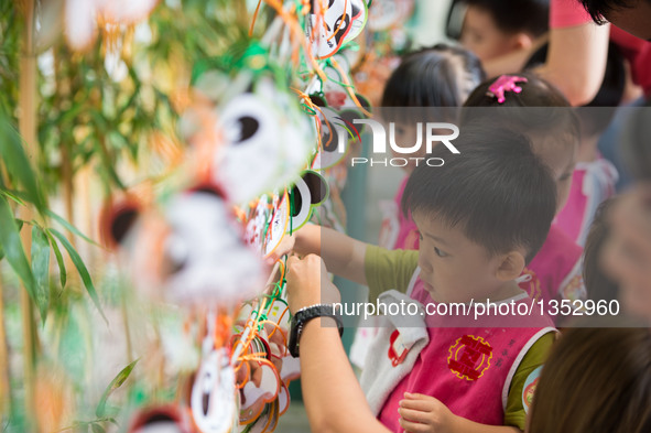 Children write down their blessings for giant panda cubs Dabao and Xiaobao in Macao Special Administrative Region, south China, July 26, 201...