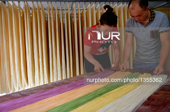 Xiao Hui (R) and Luo Xiaoqing pack colored vegetable noodles in Zhongcunba Village of Xuan'en County in Enshi, central China's Hubei Provinc...