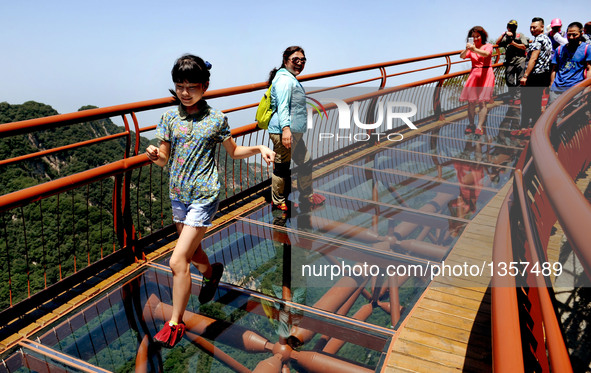 A girl runs on a 69-meter-long glass pathway built along the face of a cliff in Shaohuashan national forest park in Weinan City, northwest C...