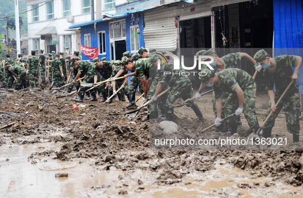 Soldiers clean up streets in Jingxing County, north China's Hebei Province, July 29, 2016. A total of 2,400 soldiers have been dispatched to...