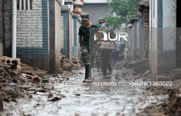 Soldiers work in a residential area in Jingxing County, north China's Hebei Province, July 29, 2016. A total of 2,400 soldiers have been dis...