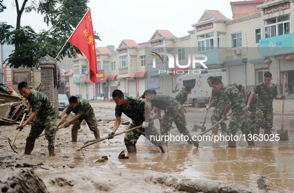 Soldiers clean up a residential area in Jingxing County, north China's Hebei Province, July 29, 2016. A total of 2,400 soldiers have been di...